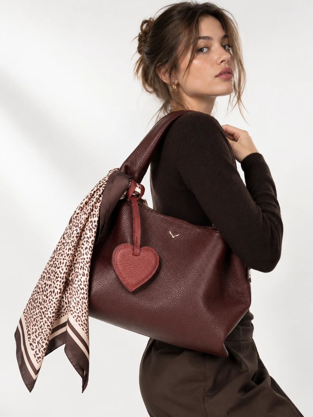 Woman carrying a Mavelania bag styled with leather accessories