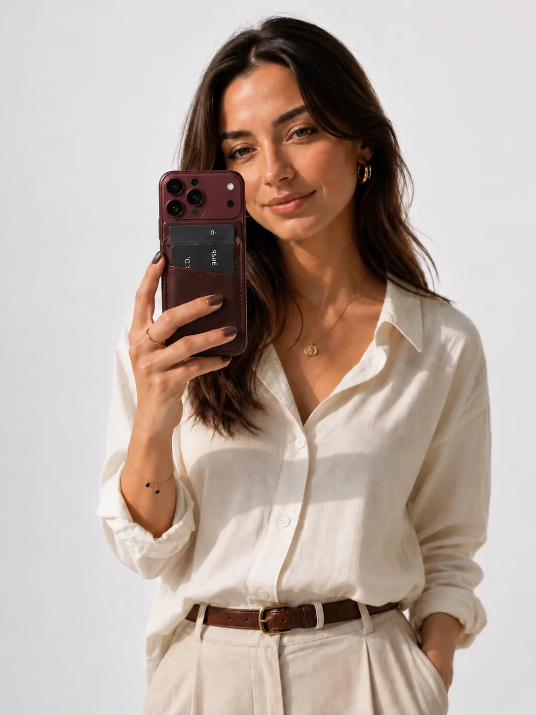 Female model holding a leather phone case with card slots